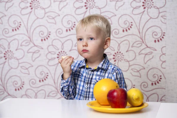 Beautiful little baby boy eats banana — Stock Photo, Image