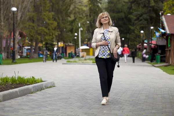 Donna anziana che cammina nel parco primaverile — Foto Stock