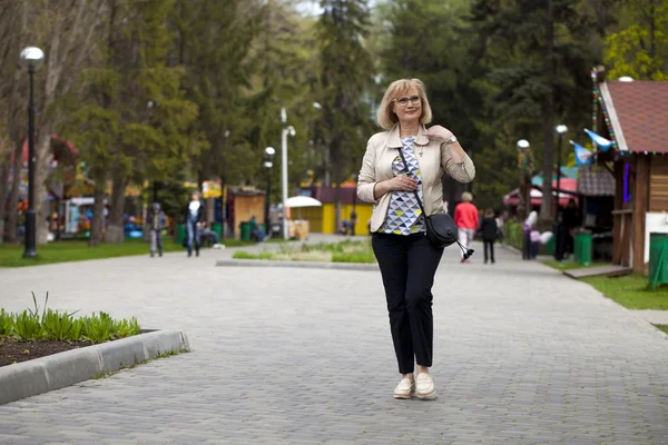 Mulher idosa andando no parque primaveril — Fotografia de Stock