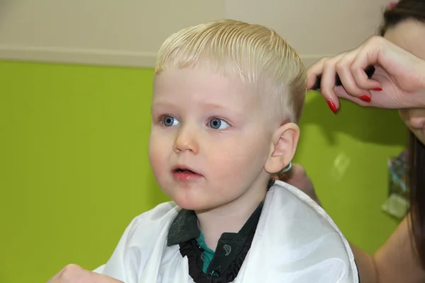 Blond liten pojke klippte sitt hår i barnens frisör — Stockfoto