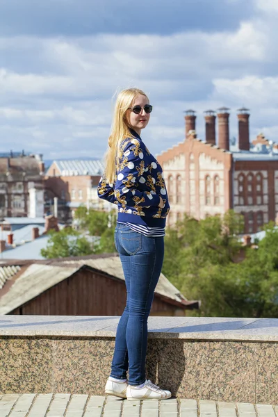 Menina bonita nova em jeans azul e uma jaqueta de couro preto em — Fotografia de Stock