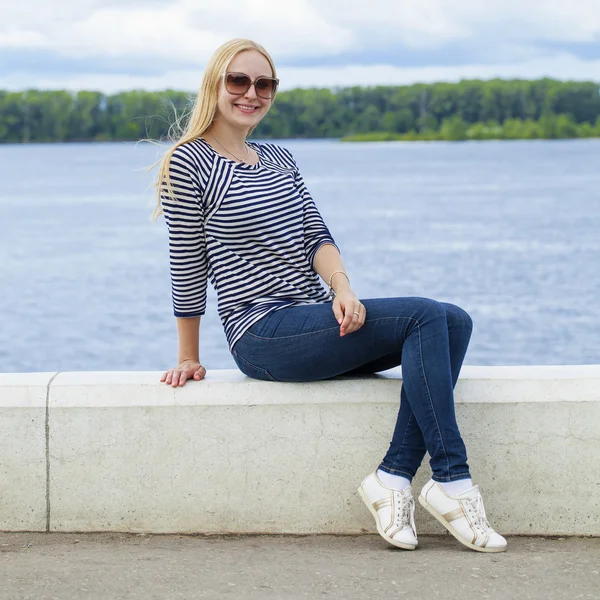 Mavi Jeans yaz sokak nieumiem oturan genç güzel kadın — Stok fotoğraf