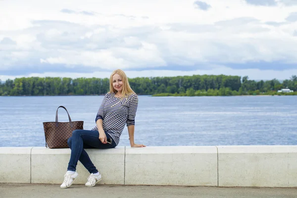 Ung vacker kvinna i blå jeans sitter i sommar gatan par — Stockfoto