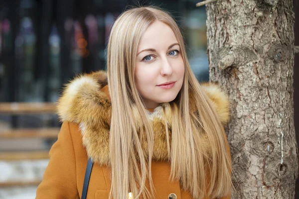 Szczęśliwa młoda kobieta blondynka na tle ulicy zima — Zdjęcie stockowe