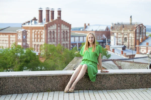 Молода красива жінка в зеленому платті позує на відкритому повітрі в сонячному — стокове фото