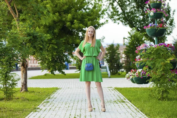 Jovem mulher bonita em vestido verde posando ao ar livre em ensolarado nós — Fotografia de Stock