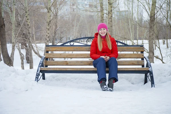 Genç kadın bir kış parkı bir arka plan üzerinde poz — Stok fotoğraf