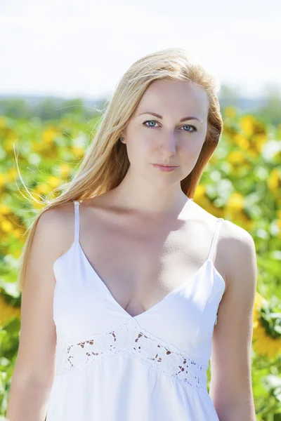 Portrait d'une belle jeune femme blonde en robe blanche sur une — Photo