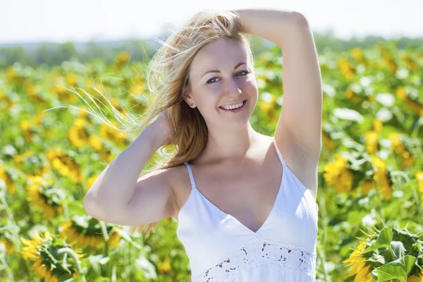 Porträt einer schönen jungen blonden Frau in einem weißen Kleid auf einem — Stockfoto