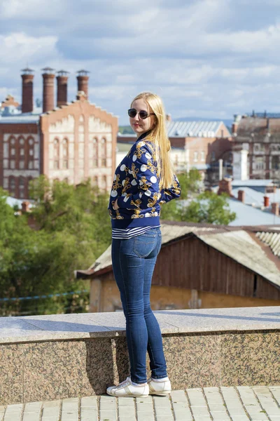 Menina bonita nova em jeans azul e uma jaqueta de couro preto em — Fotografia de Stock