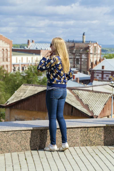 Young beautiful girl in blue jeans and jacket on the background — Stock Photo, Image