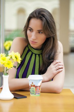 Bir kafede oturan mutlu güzel esmer kız