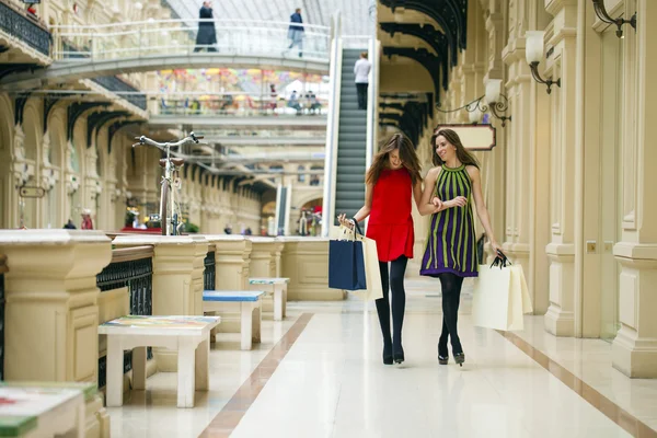 在购物上的两个女友走上袋的大型购物中心 — 图库照片