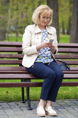 Olgun güzel sarışın kadını cep telefonundan arıyor