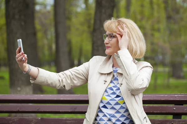 Reife schöne blonde Frau ruft auf einem Handy an — Stockfoto