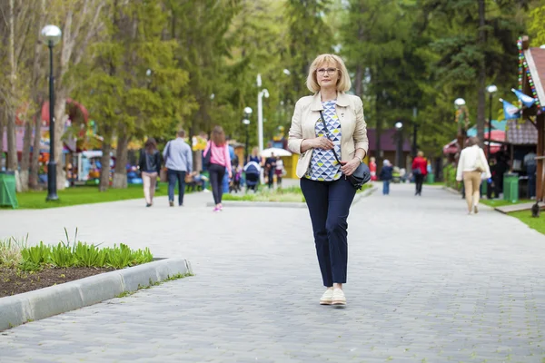 Mujer mayor caminando en el parque de primavera —  Fotos de Stock