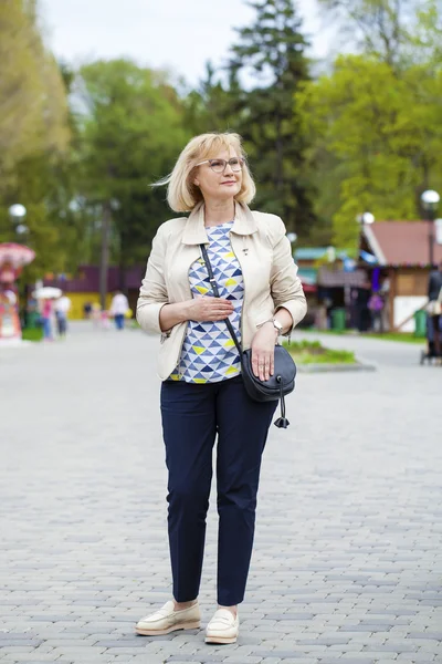 Seniorin geht im Frühlingspark spazieren — Stockfoto