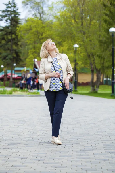 Äldre kvinna promenader i vår park — Stockfoto