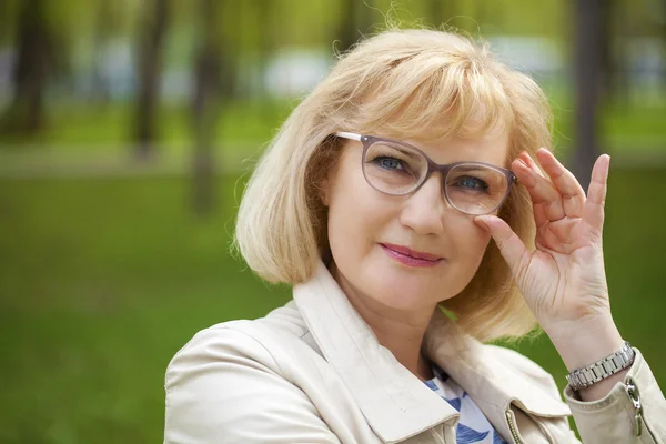 Close up portrait of lovely middle aged woman in the summer park — Stock Photo, Image