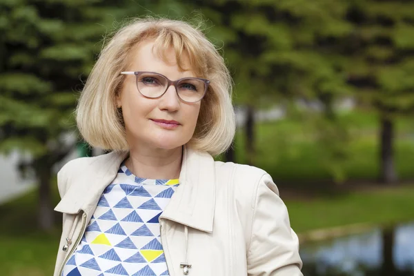 Close up portrait of lovely middle aged woman in the summer park — Stock Photo, Image