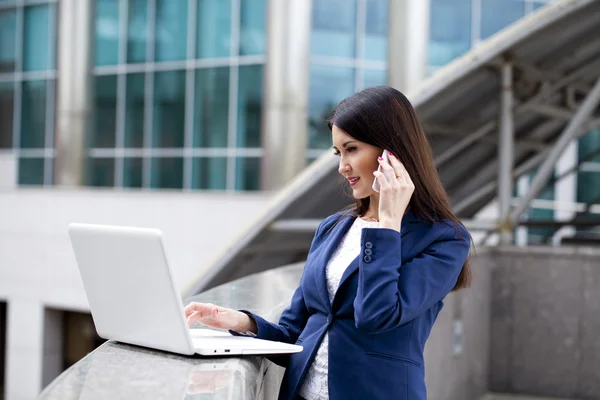 Ung brunett kvinna ringer via telefon — Stockfoto