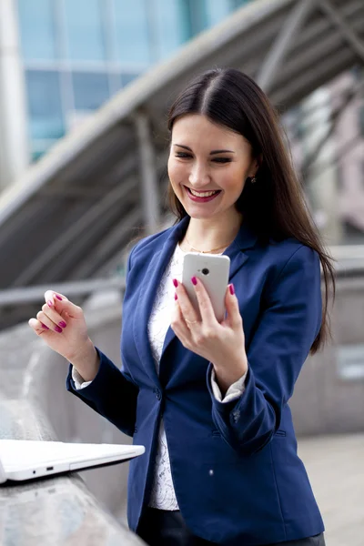 Junge brünette Frau liest eine Nachricht am Telefon — Stockfoto