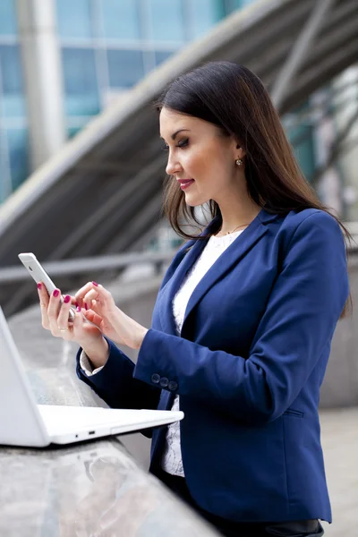 Jeune femme brune lisant un message au téléphone — Photo