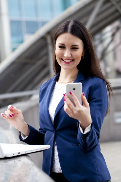 Jonge brunette vrouw lezen van een bericht op de telefoon — Stockfoto