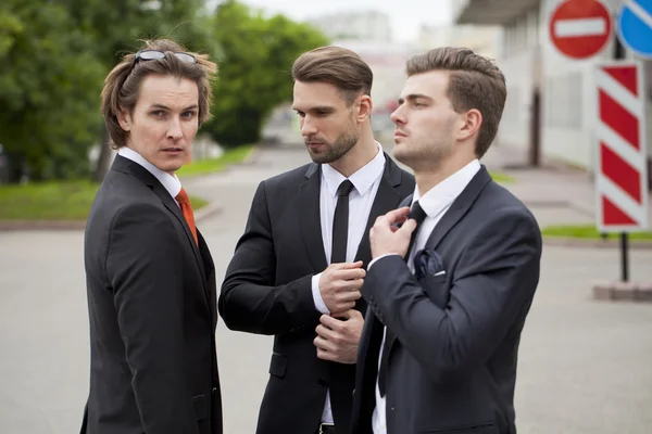 Três jovens em ternos de negócios elegantes — Fotografia de Stock