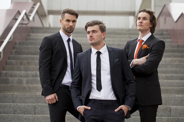 Três jovens em ternos de negócios elegantes — Fotografia de Stock