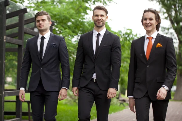 Tres jóvenes con elegantes trajes de negocios — Foto de Stock