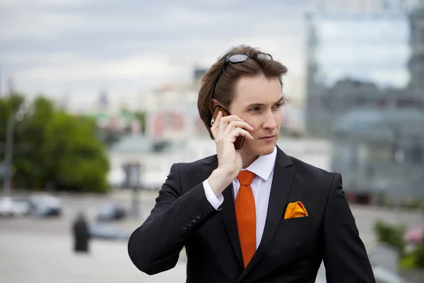 Ung framgångsrik affärsman ringer via telefon — Stockfoto