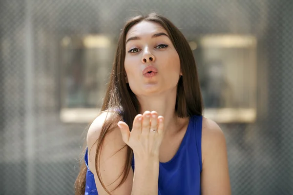 Baci soffiati, giovane donna bruna caucasica — Foto Stock