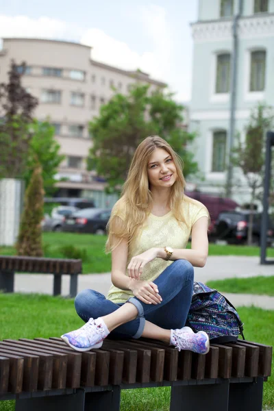 Joven hermosa chica sentada en un banco en el parque de verano —  Fotos de Stock