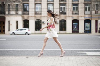 Yürürken beyaz çiçekler içinde genç güzel esmer kadın