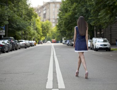 Yolda yürürken kısa mavi bir elbise genç güzel kadın