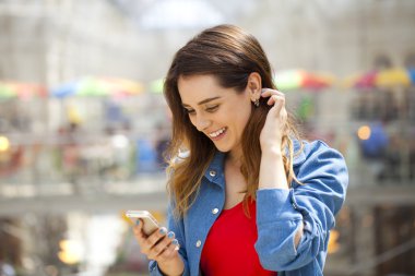 Genç esmer kadın telefonda mesaj okuma