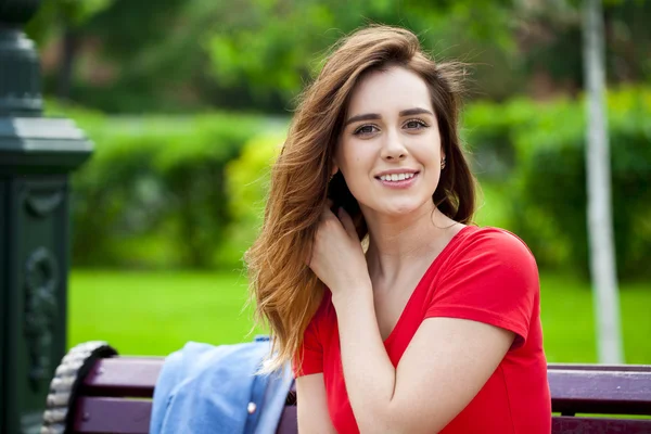 Beautiful young brunette girl in a red dress — Stock Photo, Image