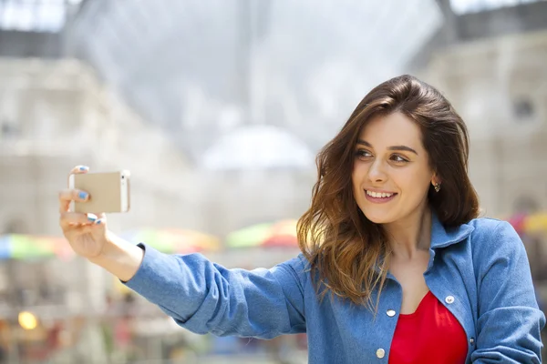 Hermosa, sonriente mujer tomar una foto de sí misma con un smartp — Foto de Stock