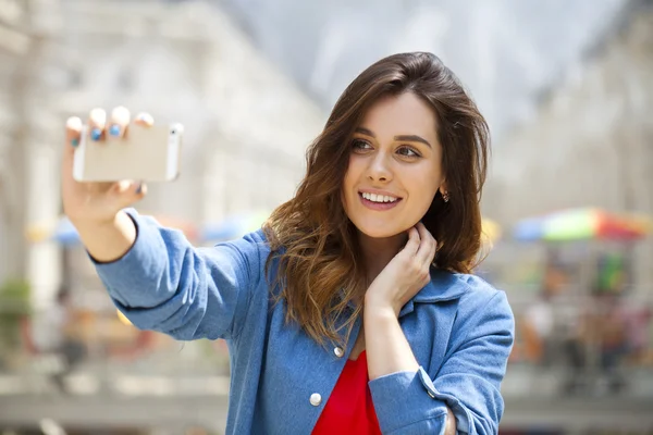 Bella, donna sorridente scattare una foto di se stessa con uno smartphone — Foto Stock