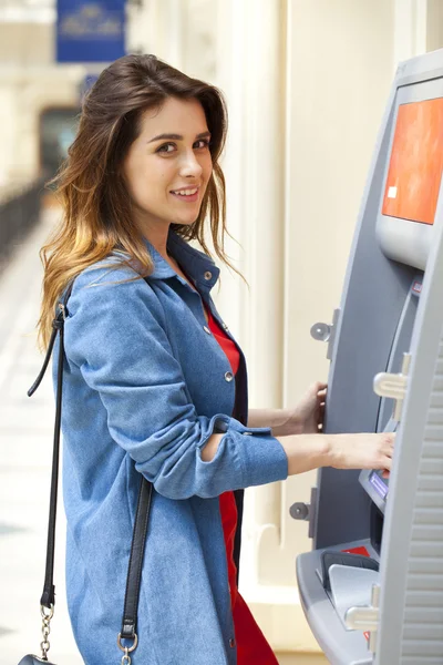 Mujer morena feliz retirando dinero de la tarjeta de crédito en el cajero automático — Foto de Stock