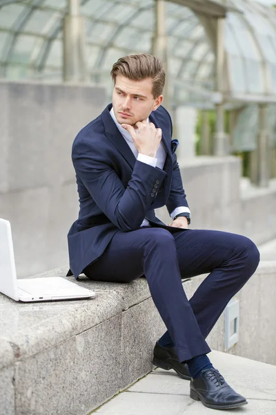Portrait of a young successful businessman with a laptop — Stock Photo, Image