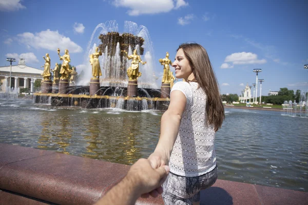 Seguitemi. Giovane ragazza felice tira la mano ragazzi — Foto Stock