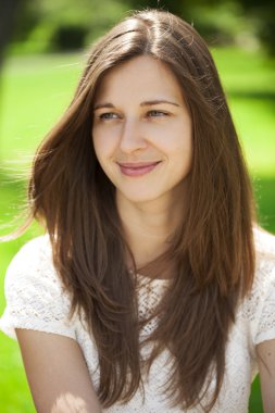 Gülümseyen genç bir kadının yakın plan portresi.