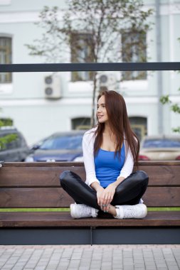 Yaz parkta bir bankta oturan genç güzel kız