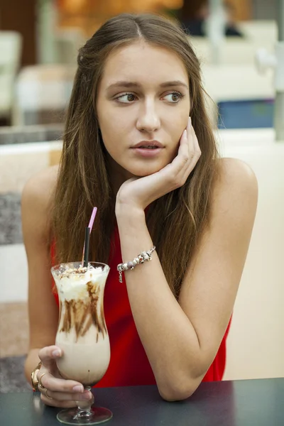 Молода жінка п'є коктейль в кафе — стокове фото