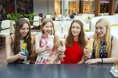 Dört çekici genç kadın kokteyller shopp içinde içme kapatın