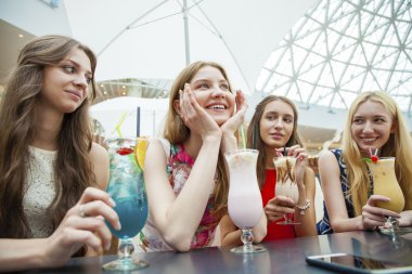 Dört çekici genç kadın kokteyller shopp içinde içme kapatın