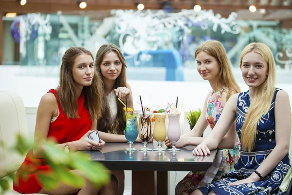 Закрыть четыре привлекательные молодые женщины, пьющие коктейли в магазине — стоковое фото