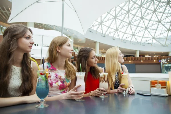 Close up four attractive young women drinking cocktails in shopp — Stock Photo, Image